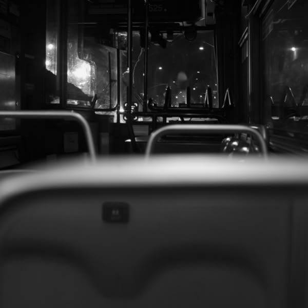 A bus seat with a button on the back of it.