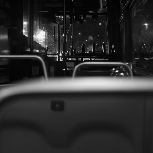 A bus seat with a button on the back of it.