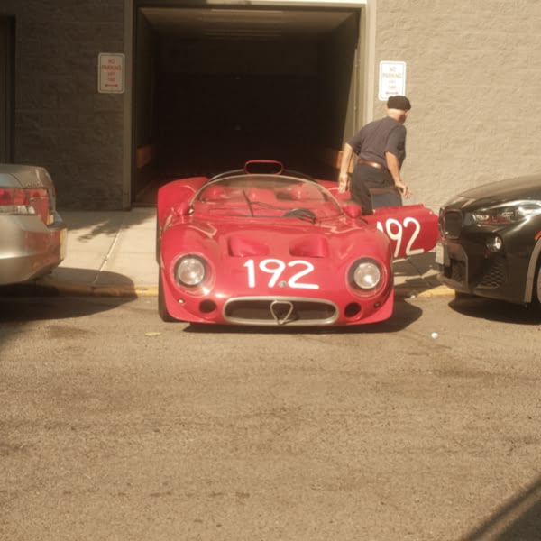 A red sports car is parked in front of a garage.