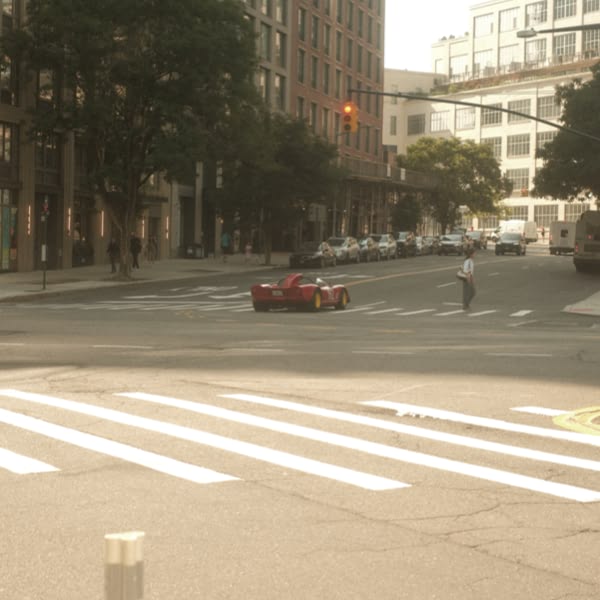 A red car is driving down a street.