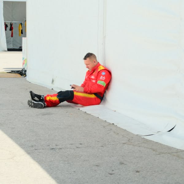 A man in a red suit is sitting on the ground.