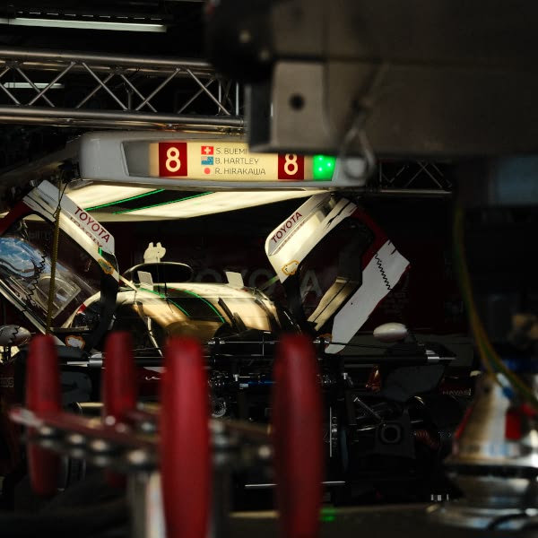 A red and white car with a green light on.