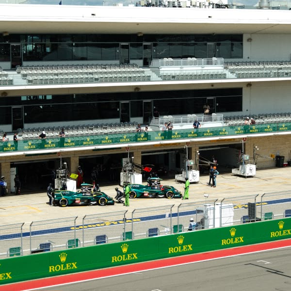 A green race car is parked in a garage.