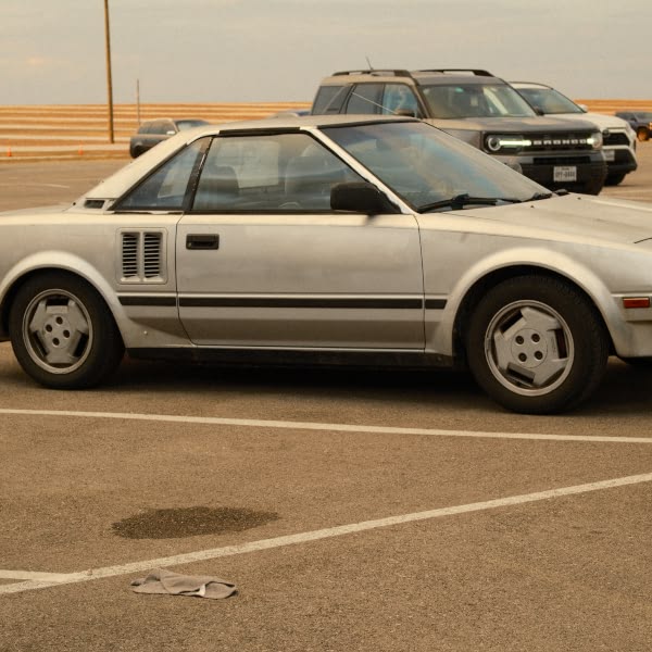 A silver car is parked in a parking lot.