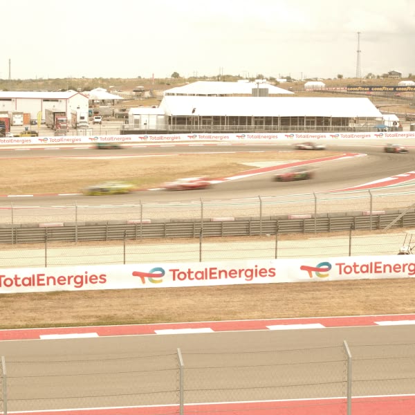 A race track with cars driving around it.