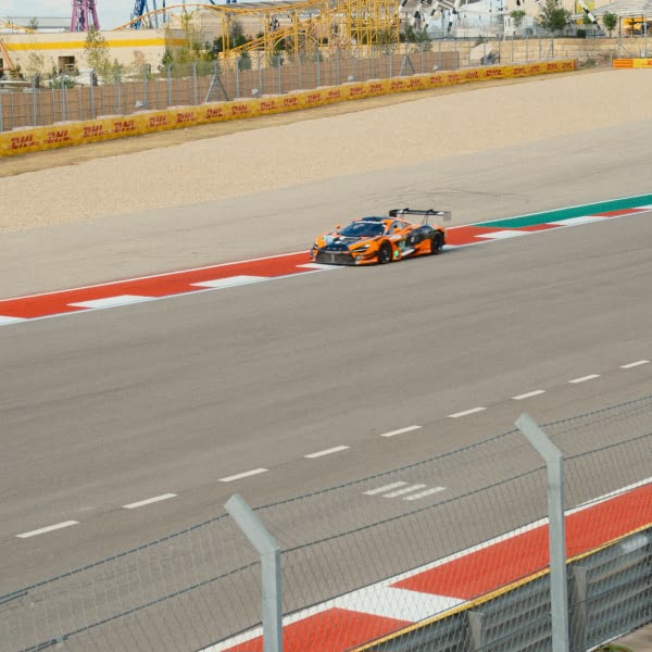 A race car is driving on a race track.