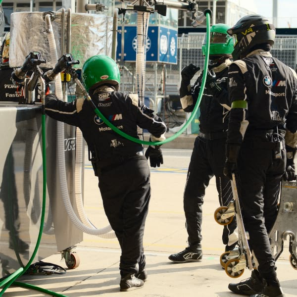 A man wearing a green helmet and black pants.