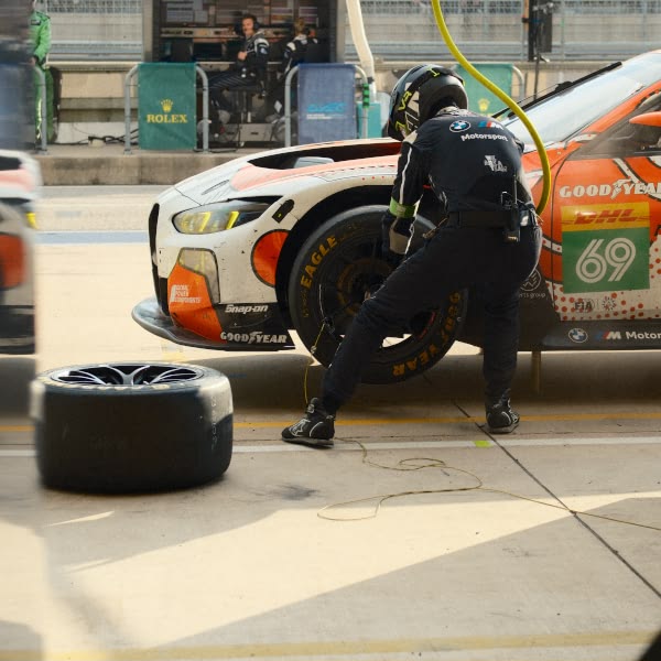 A man is working on a car tire.