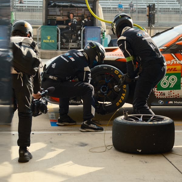 Two men working on a car tire.