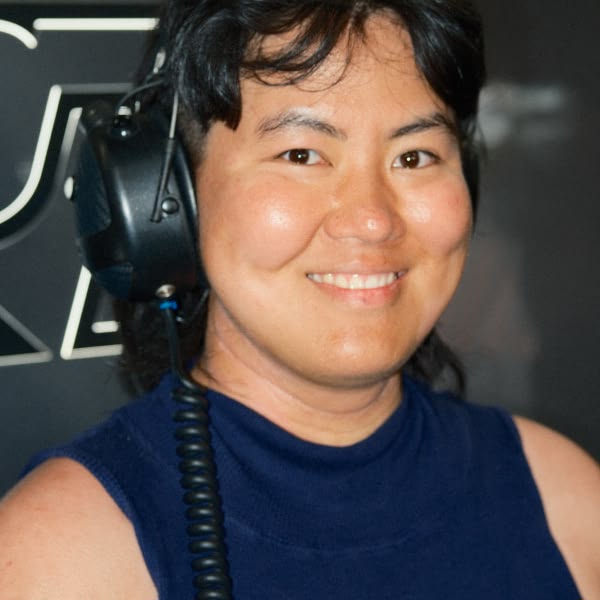 A woman wearing a blue shirt and headphones.