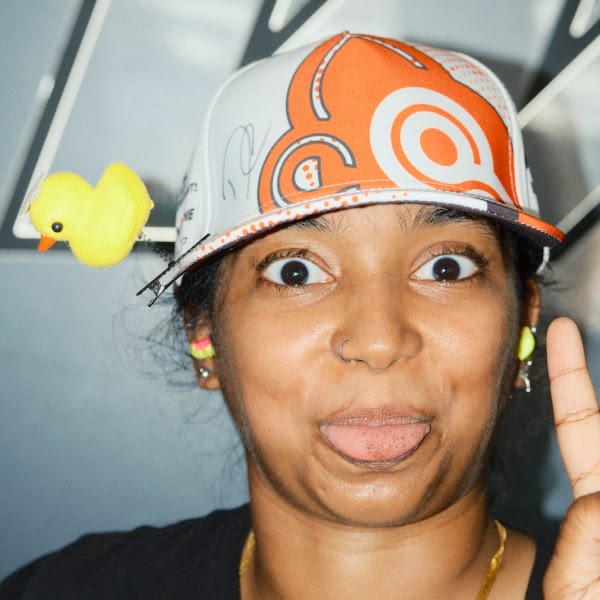 A woman wearing a hat with a duck on it.