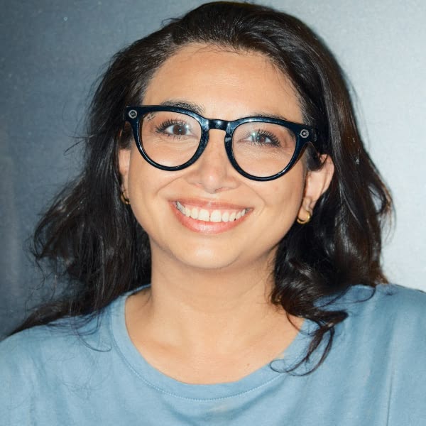 A woman wearing glasses and a blue shirt.