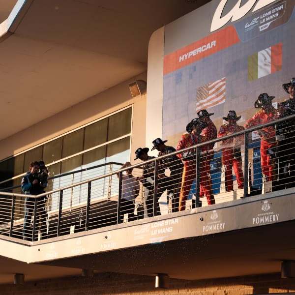 A group of people standing on a balcony.