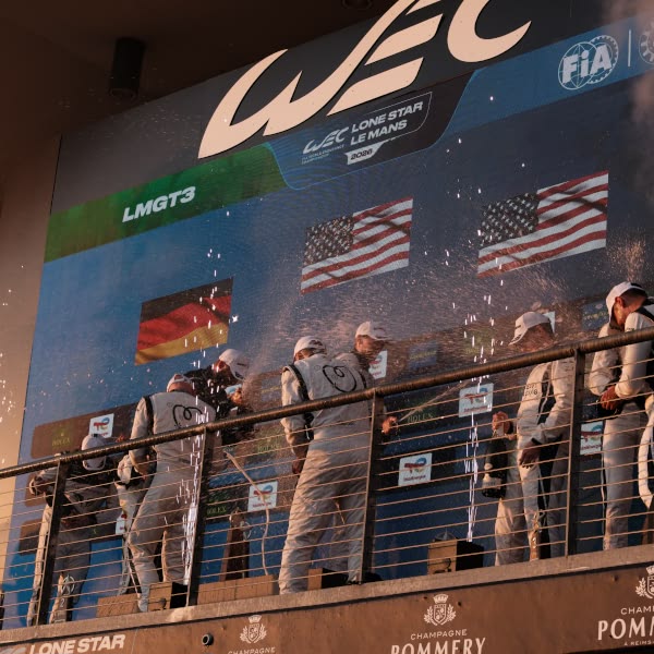 A group of people wearing white uniforms stand on a balcony.