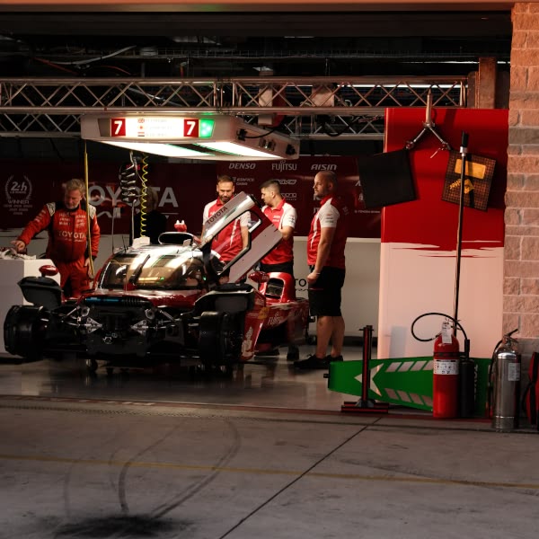 A group of men working on a race car.