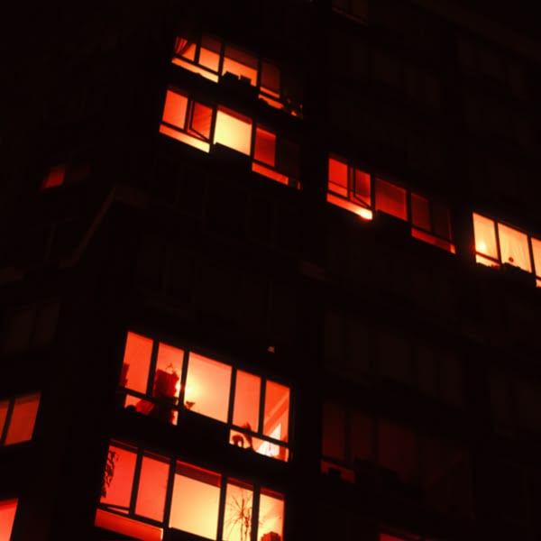 A tall building with many windows lit up.