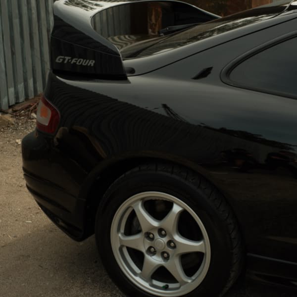 A black car with a spoiler on the back.