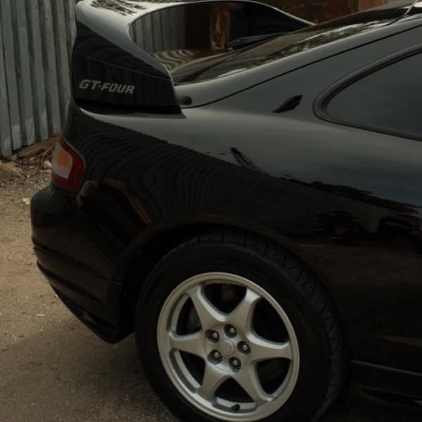 A black car with a spoiler on the back.