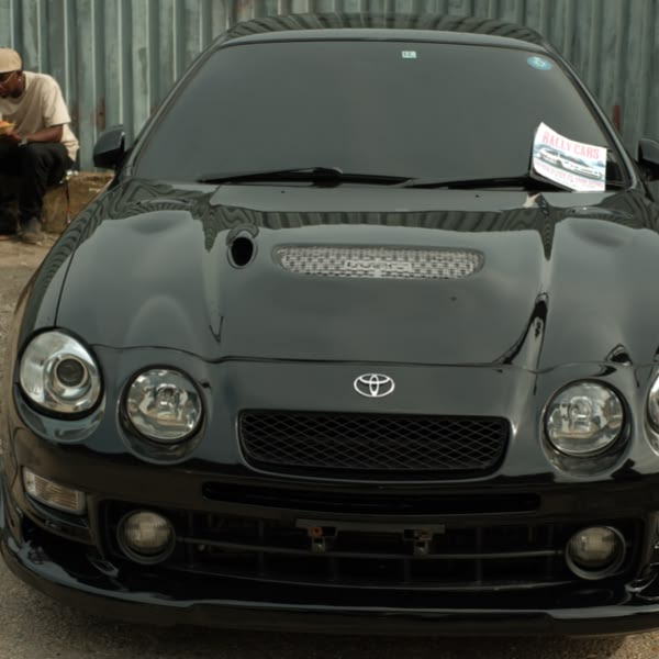 A black car with a paper on the hood.