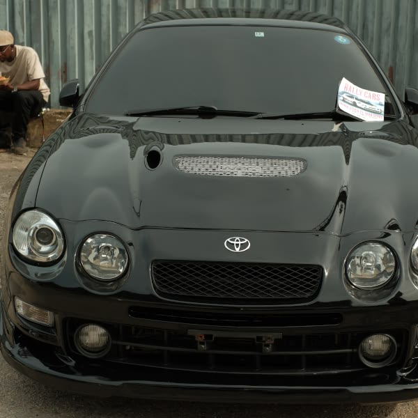 A black car with a paper on the hood.