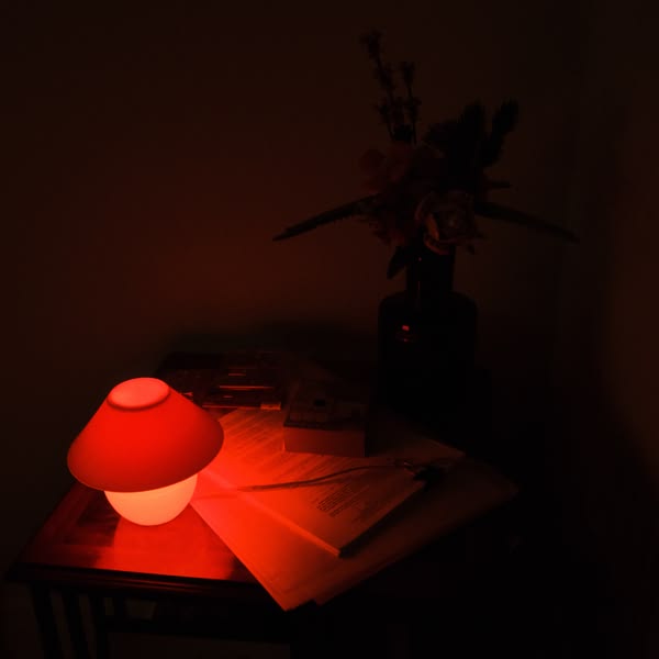 A table with a lamp and a book on it.