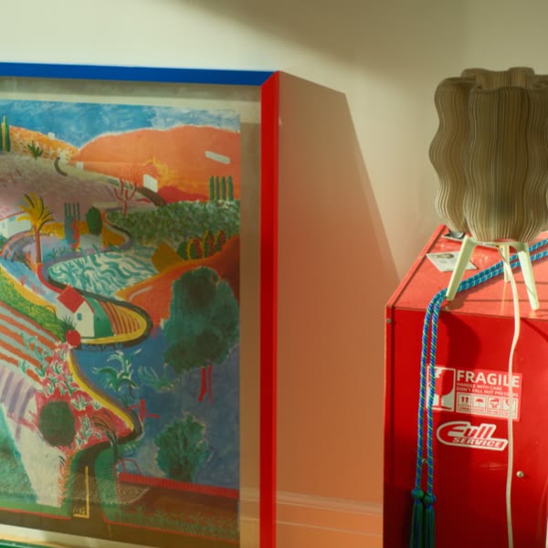 A red and blue picture frame with a painting of a field.