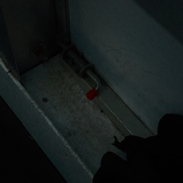 A black glove on a white wall.