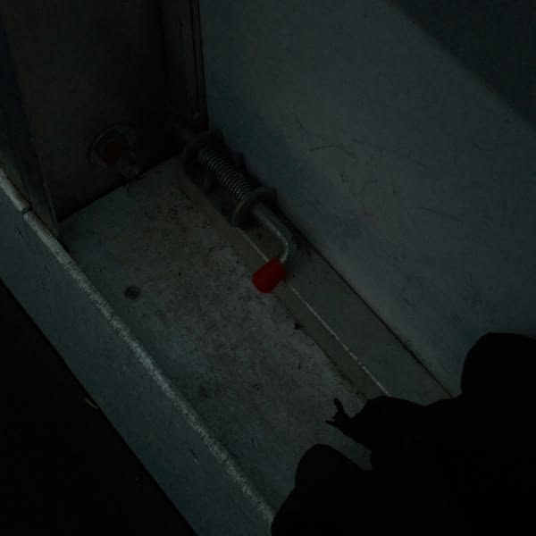 A black glove on a white wall.