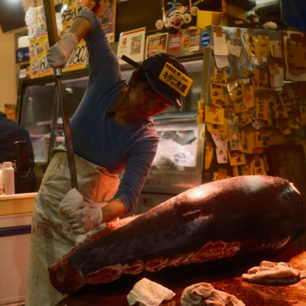 A woman cutting a large piece of meat.