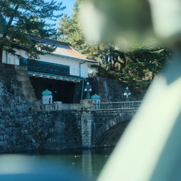 A statue of a person standing in front of a bridge.