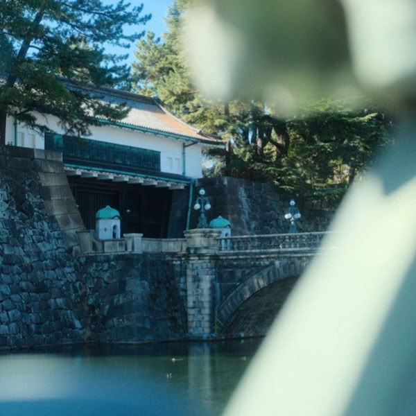 A statue of a person standing in front of a bridge.
