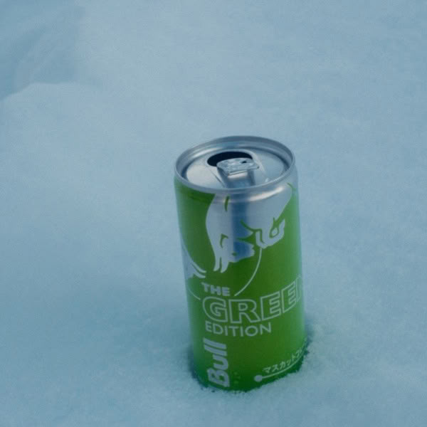 A green can of Bull is sitting in the snow.