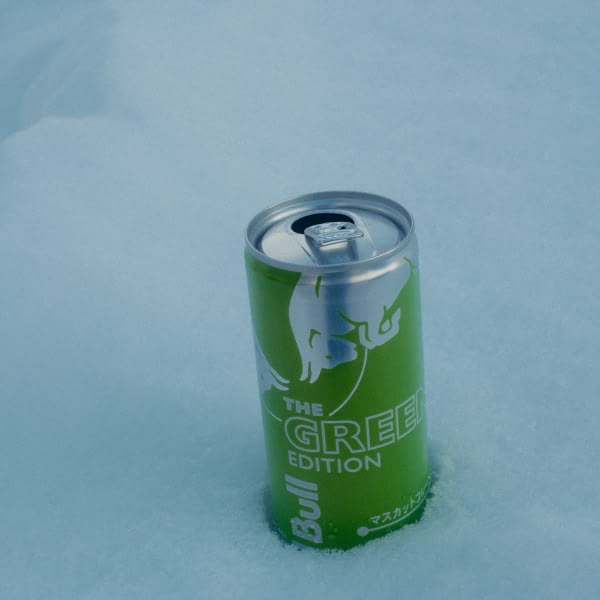 A green can of Bull is sitting in the snow.