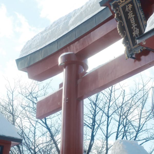A red and white pole with a snow covered roof.