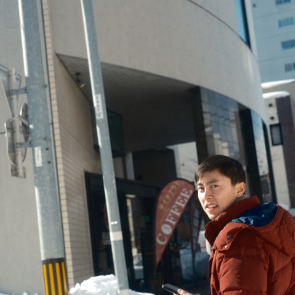 A man standing in front of a coffee shop.