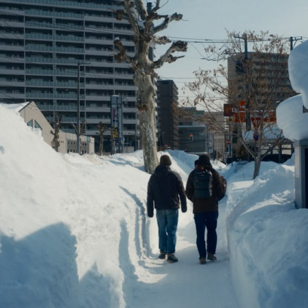Two men walking on a snowy path.