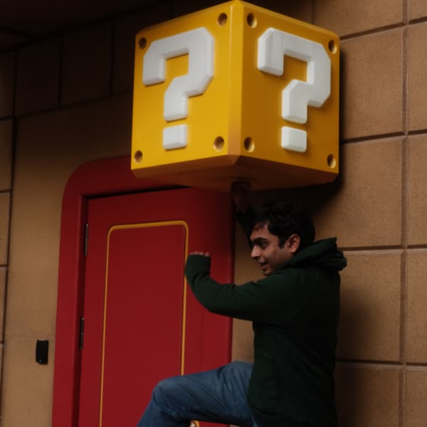 A man is standing in front of a red door.