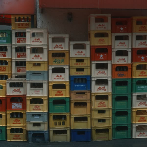 A stack of beer crates with a red, yellow, and green color scheme.