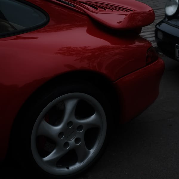 A red sports car with a white wheel.