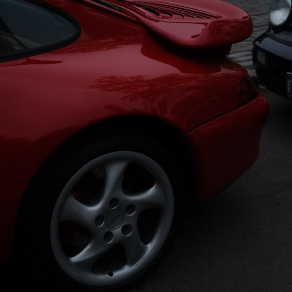 A red sports car with a white wheel.