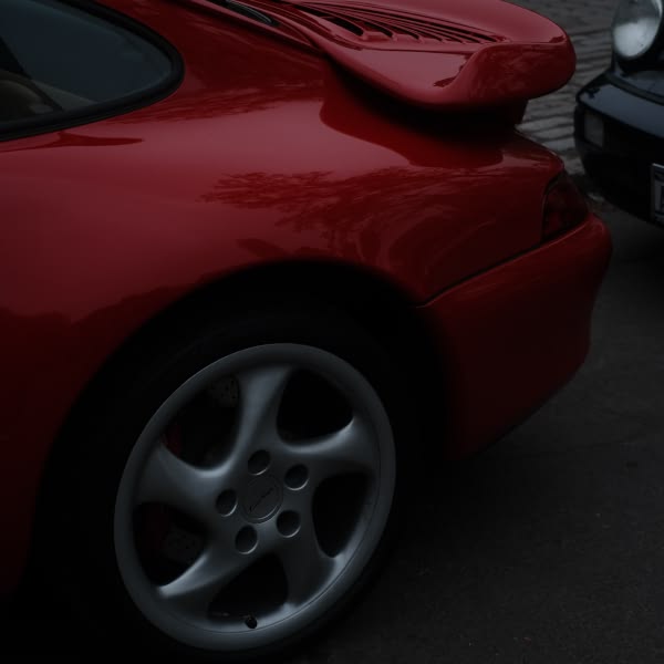 A red sports car with a white wheel.
