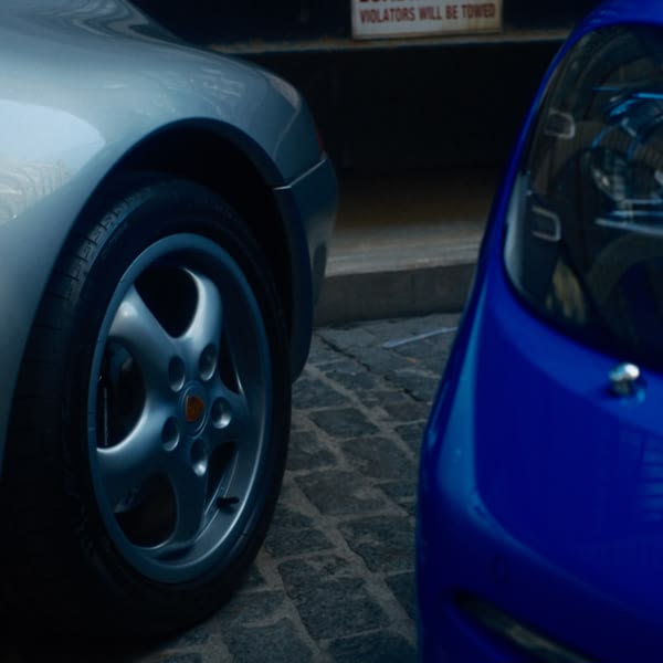 A silver car with a tire.