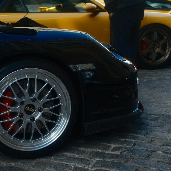 A black car with a silver wheel.