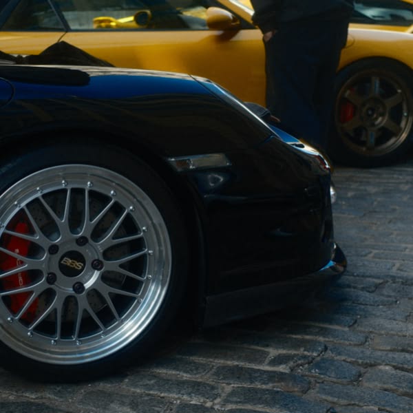 A black car with a silver wheel.