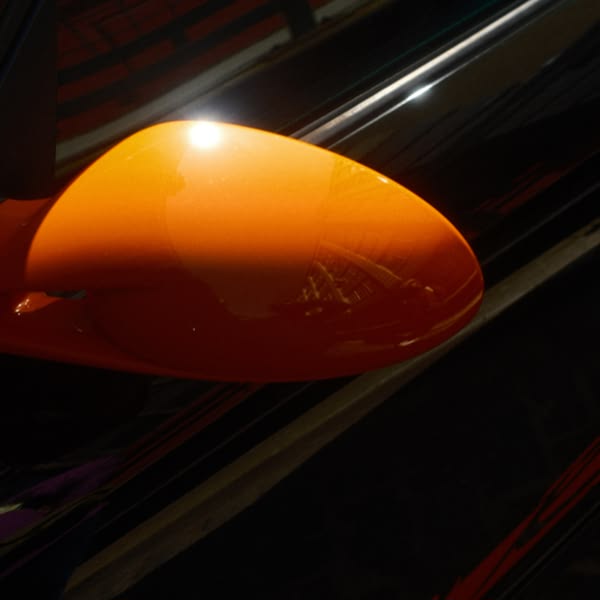 A bright orange car mirror.