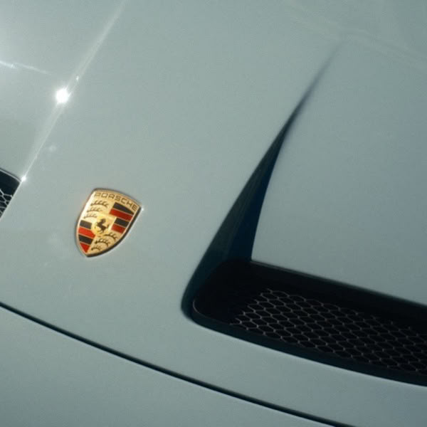 A blue car with a white emblem on the hood.