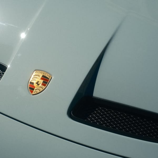 A blue car with a white emblem on the hood.