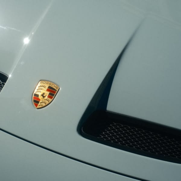 A blue car with a white emblem on the hood.
