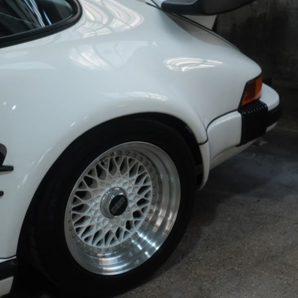 A white car with a black tire.