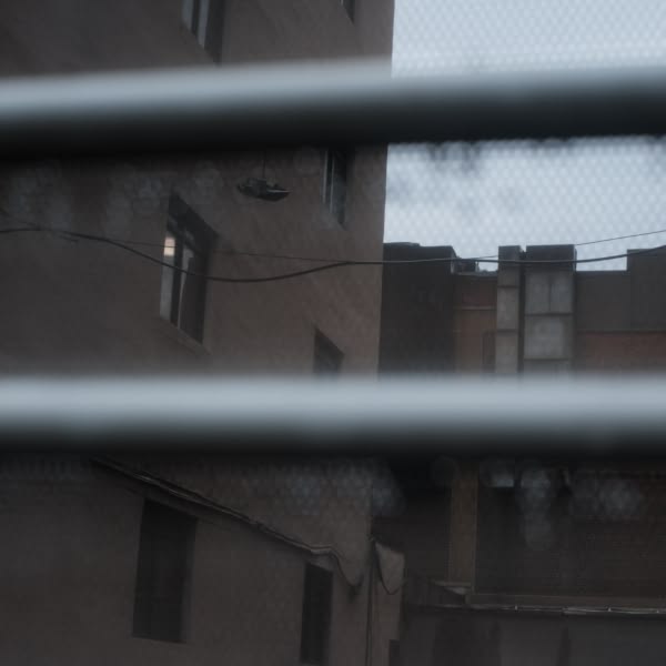 A view of a building through a metal fence.
